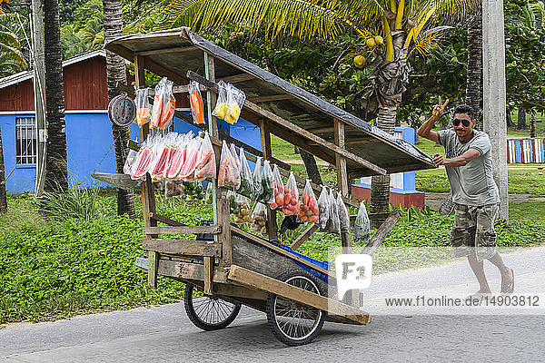 Mann verkauft Pakete mit frischen Produkten auf der Straße; Roatan  Bay Islands Department  Honduras