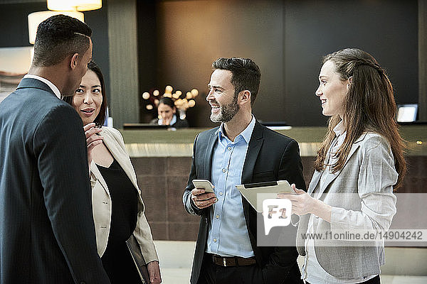 Business people standing and discussing in the hotel lobby