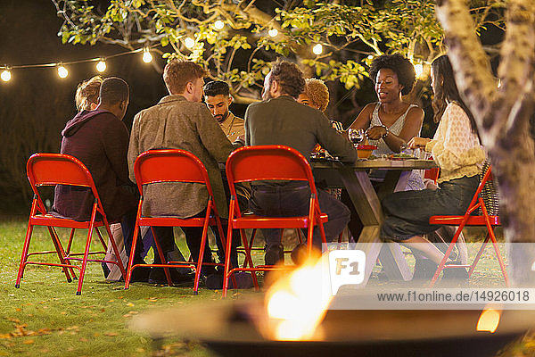 Freunde genießen das Abendessen auf einer Gartenparty