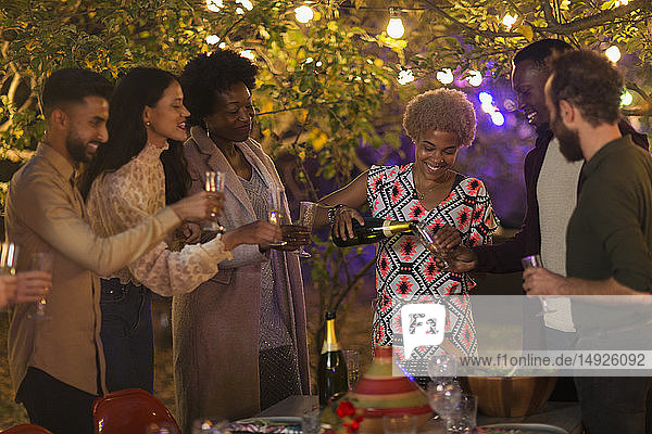 Freunde feiern  trinken Champagner beim Abendessen Gartenparty