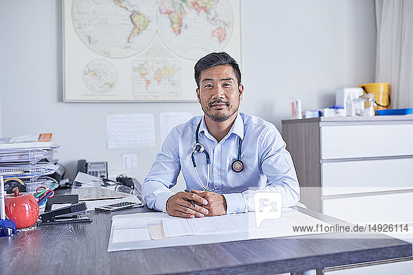 Portrait confident male doctor working in clinic doctors office