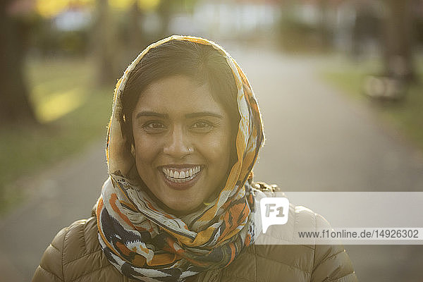 Porträt einer lächelnden  selbstbewussten muslimischen Frau mit Hidschab im Park