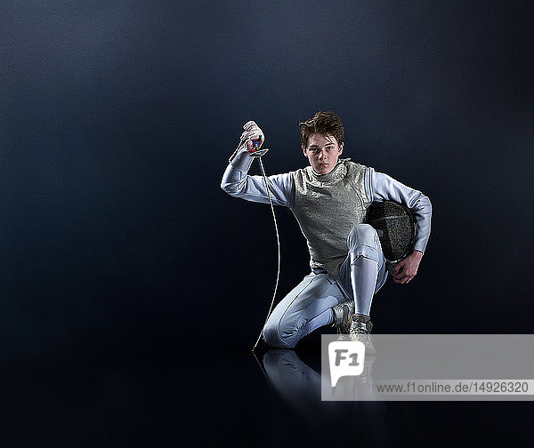 Portrait confident teenage boy fencing