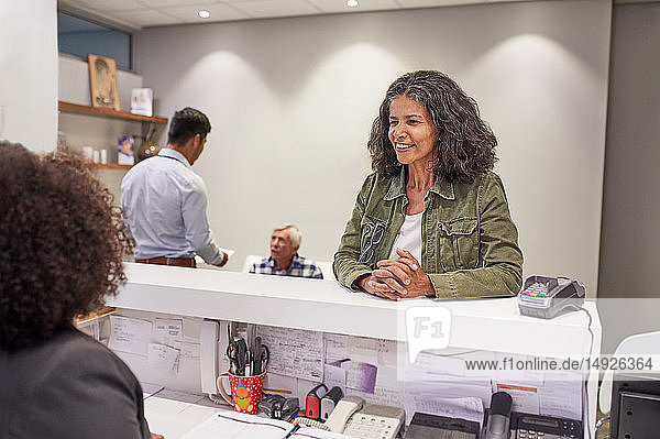 Smiling woman checking in at clinic reception