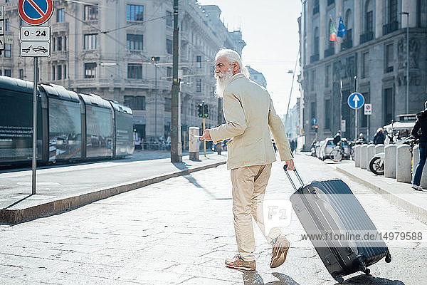Leitender Geschäftsmann mit Rollgepäck in der Stadt  Mailand  Lombardei  Italien