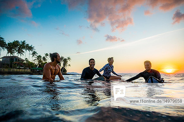 Surfer  die bei Sonnenuntergang im Meer gleiten  Pagudpud  Ilocos Norte  Philippinen