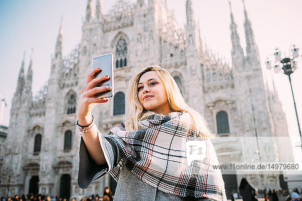 Junge Touristin beim Smartphone-Selfie vor dem Mailänder Dom  Mailand  Italien
