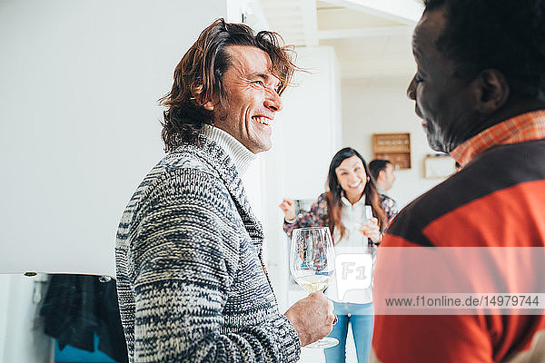 Freunde unterhalten sich auf einer Party im Loft-Büro