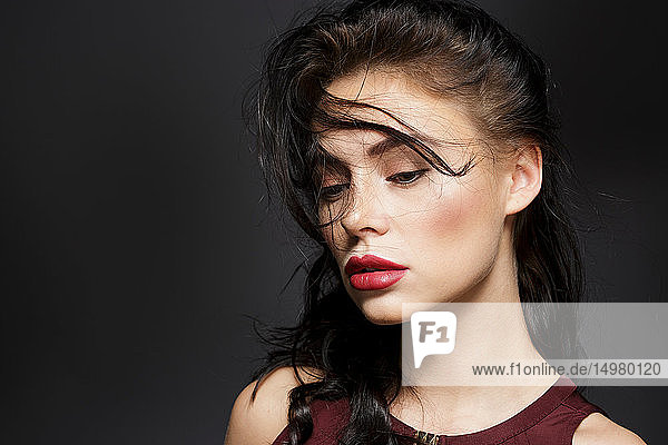 Schöne junge Frau mit langen schwarzen Fliegehaaren  Studioporträt