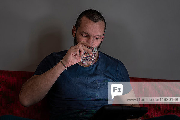 Hipster man using smartphone on sofa