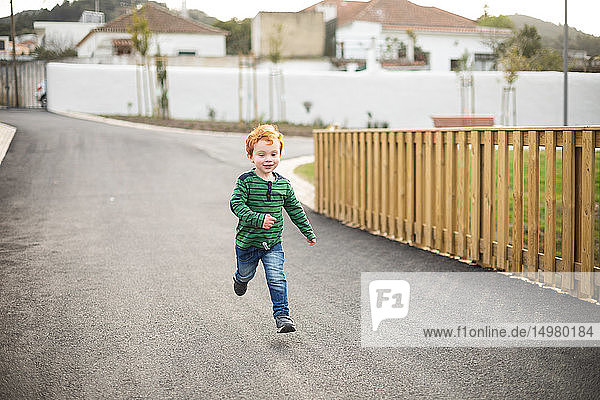 Boy running on road in residential area