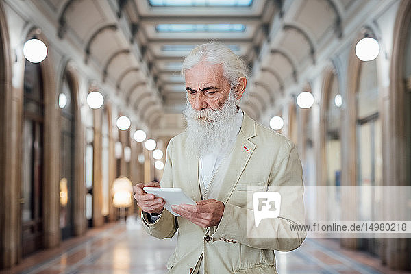 Leitender Geschäftsmann benutzt digitales Tablet im Bürogebäude  Mailand  Lombardei  Italien