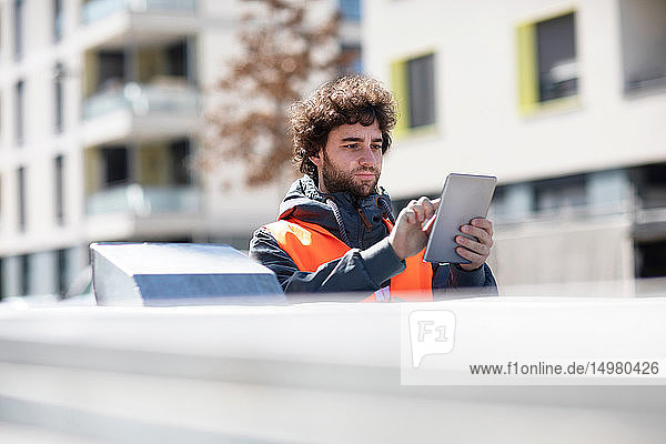 Mann benutzt digitales Tablett auf der Straße