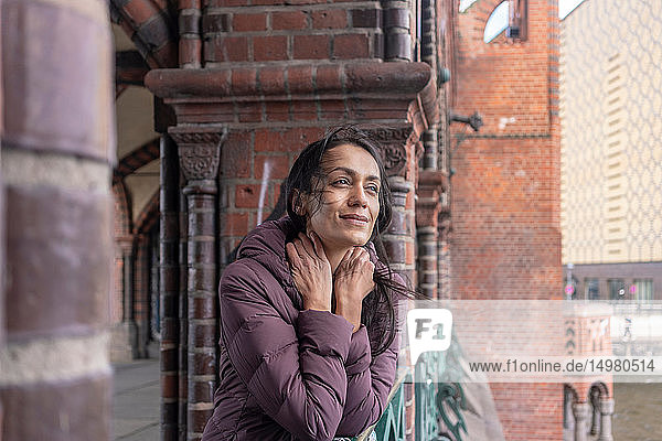 Woman leaning against railings of old building