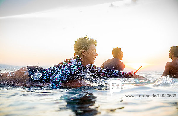 Surfer  der bei Sonnenuntergang im Meer gleitet  Pagudpud  Ilocos Norte  Philippinen