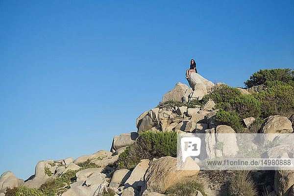 Frau auf Felsen sitzend  Villasimius  Sardinien  Italien