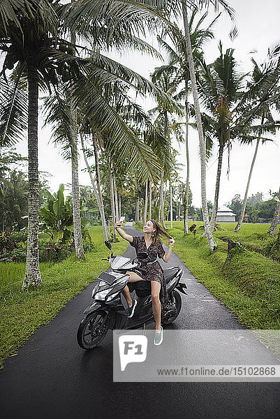 Junge Frau macht Selfie auf dem Motorrad in Bali  Indonesien