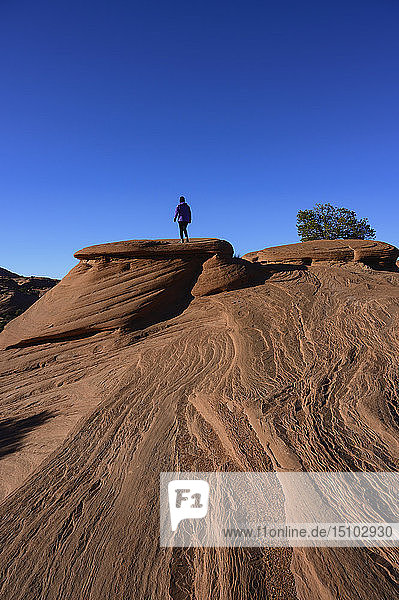 Frau geht auf glattem Felsen im Monument Valley,  Arizona,  USA