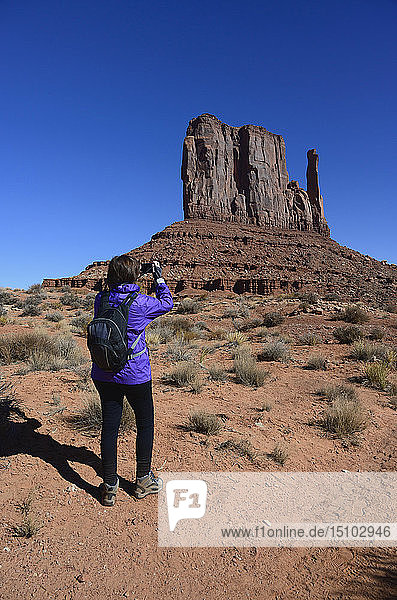 Frau beim Fotografieren eines Felsens im Monument Valley,  Arizona,  USA