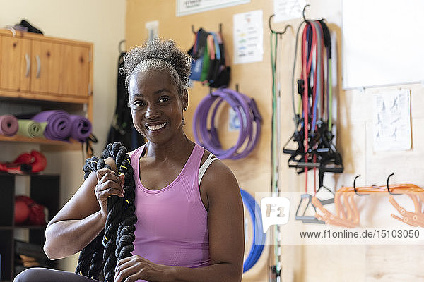 Lächelnde Frau mit Seil im Fitnessstudio