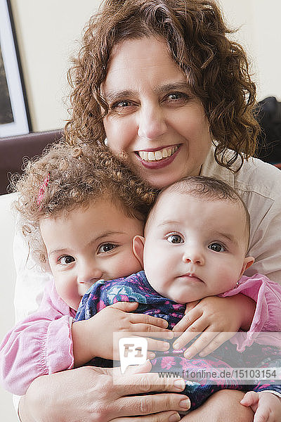 Smiling woman holding her two daughters