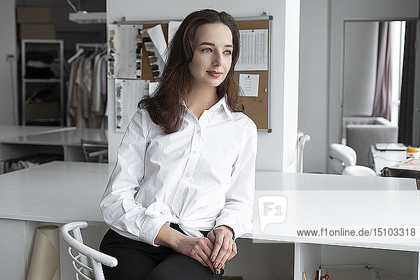 Modedesignerin sitzt am Schreibtisch