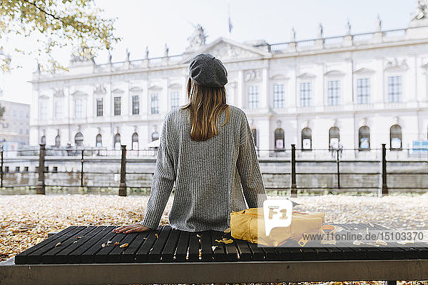 Junge Frau sitzt auf einer Parkbank in der Nähe des Deutschen Historischen Museums in Berlin  Deutschland