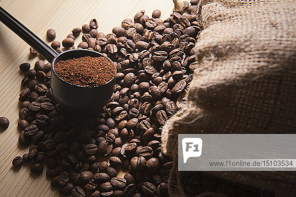 Siebträger mit gemahlenem Kaffee auf gerösteten Kaffeebohnen