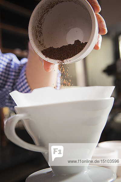 Barista schüttet Kaffeesatz in den Filter