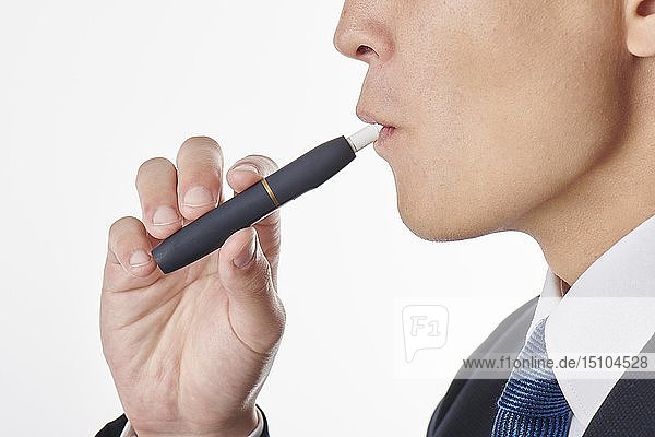 Young Japanese man smoking electronic cigarette