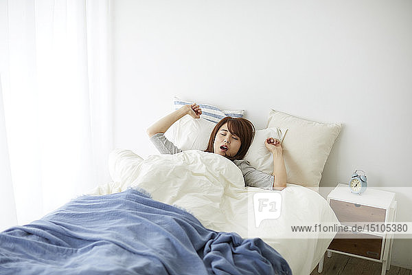 Young Japanese woman in bed in the morning