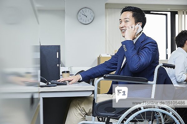 Japanese young man on wheelchair working