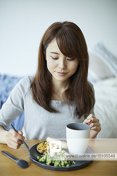 Young Japanese woman having breakfast at home