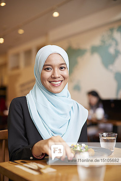 Junge südostasiatische Frau beim Essen im Restaurant
