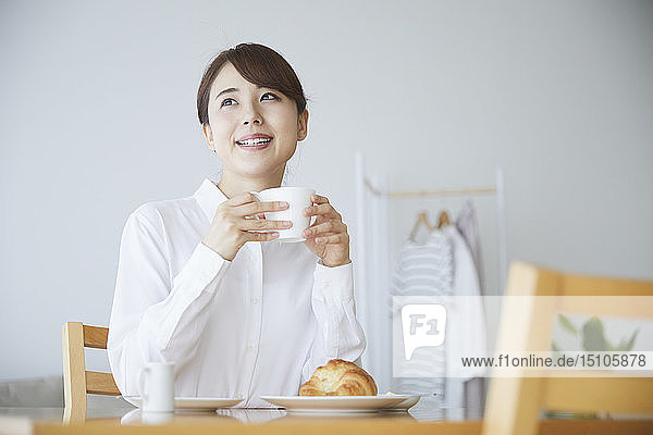 Young Japanese woman having breakfast at home
