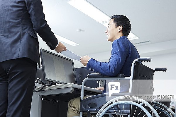 Japanese young man on wheelchair working