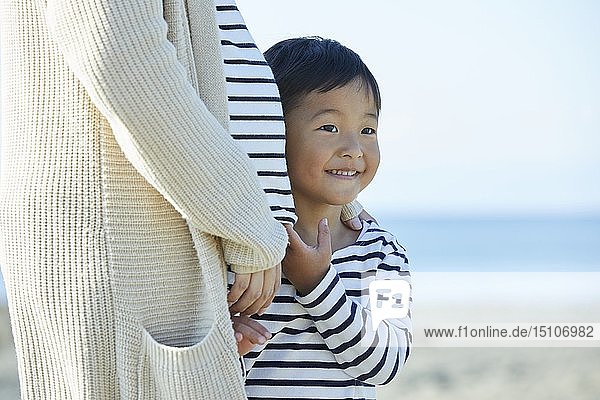 Japanisches Kind mit Mutter am Strand
