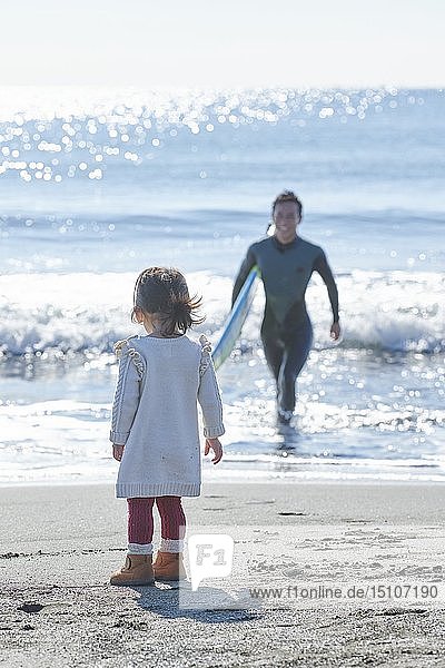 Japanisches Kind mit Vater am Strand
