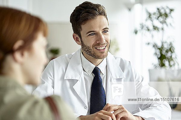 Smiling doctor talking with patient