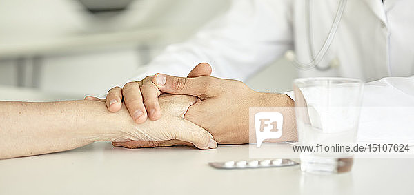 Close-up of doctor holding patient's hand