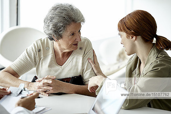 Frau im Gespräch mit ihrer Mutter in der Klinik