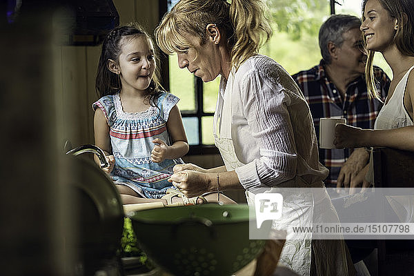 Mature woman cooking with her granddaughter in kitchen
