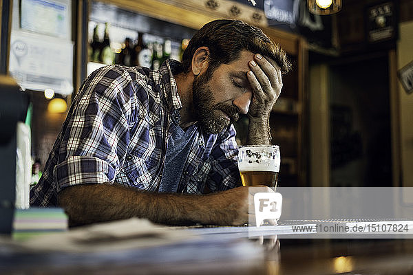 Sad man sitting in beer bar