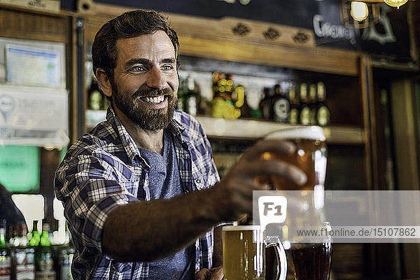 Smiling man serving beer
