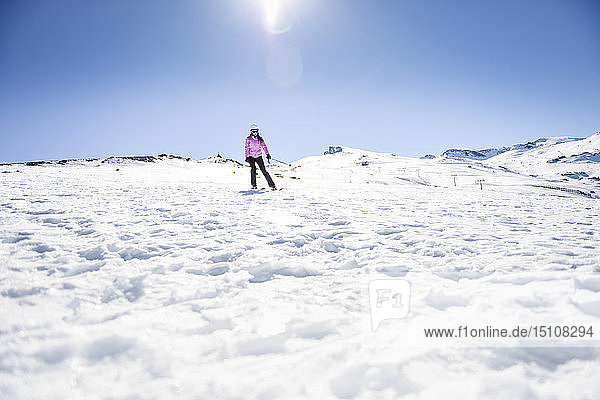 Frau fährt Ski unter blauem Himmel  Sierra Nevada  Andalusien  Spanien