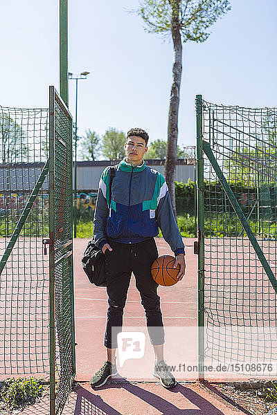 Young man with basketball at basketball court