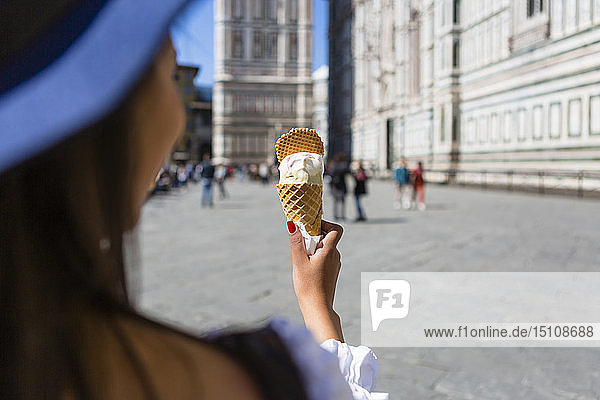Italy  Florence  Piazza del Duomo  back view of young tourist holding ice cream cone