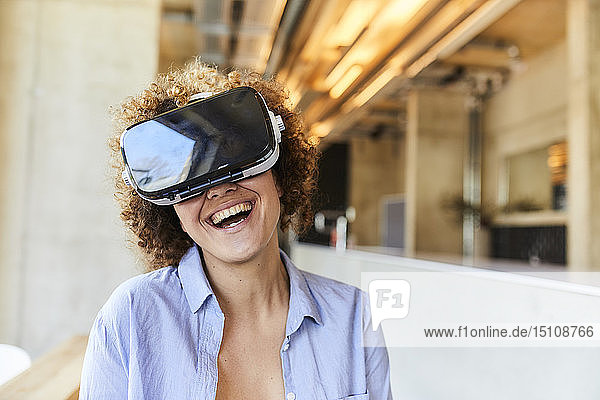 Glückliche Frau mit VR-Brille im modernen Büro