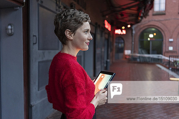 Germany  Berlin  profile of confident businesswoman with digital tablet outdoors