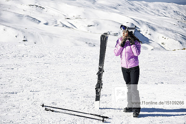 Frau in Skikleidung bereitet sich in der Sierra Nevada  Andalusien  Spanien  auf das Skifahren vor